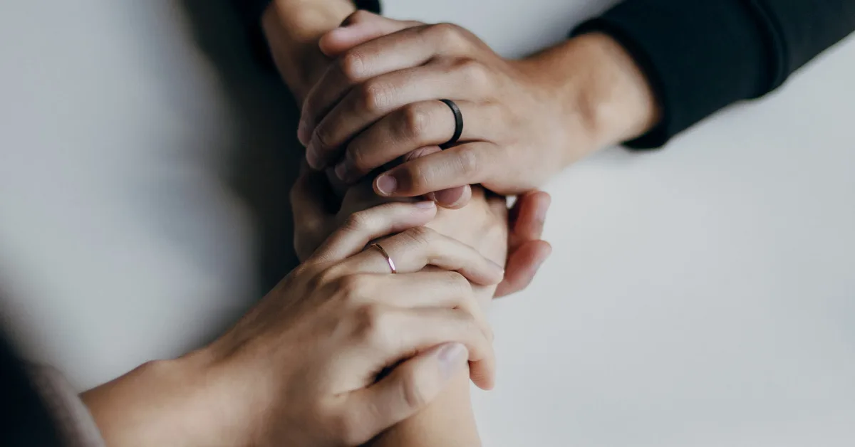Multiple hands held together.