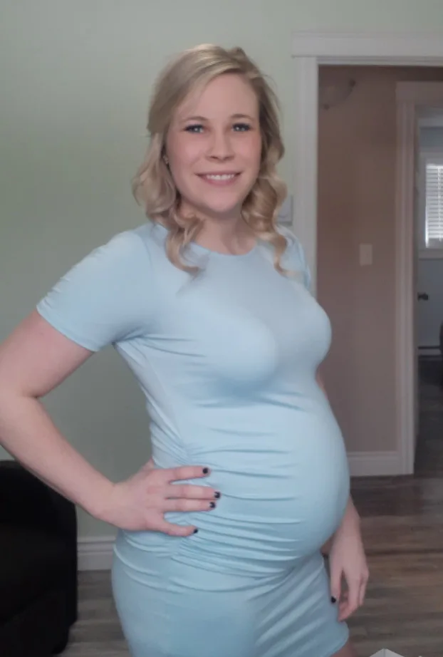 A pregnant woman with blonde hair and a blue dress.